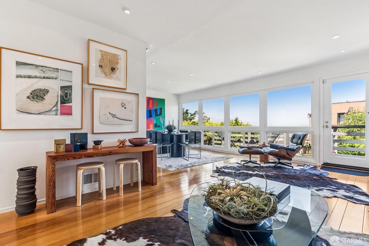 The deck off the living room at 138 Clifford Terrace at twilight, with butterfly chairs and an open view over treetops to the city and hills