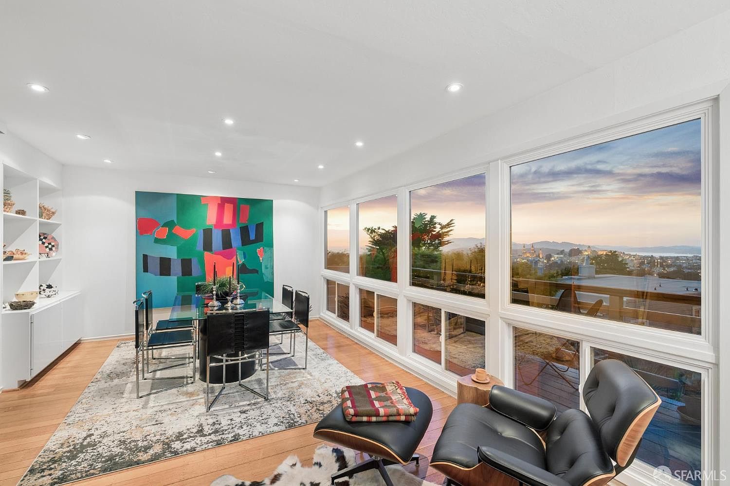 Dining room at 138 Clifford Terrace with a black table, a large color-block painting, and a wall of glass holding the Bay and Marin Headlands view
